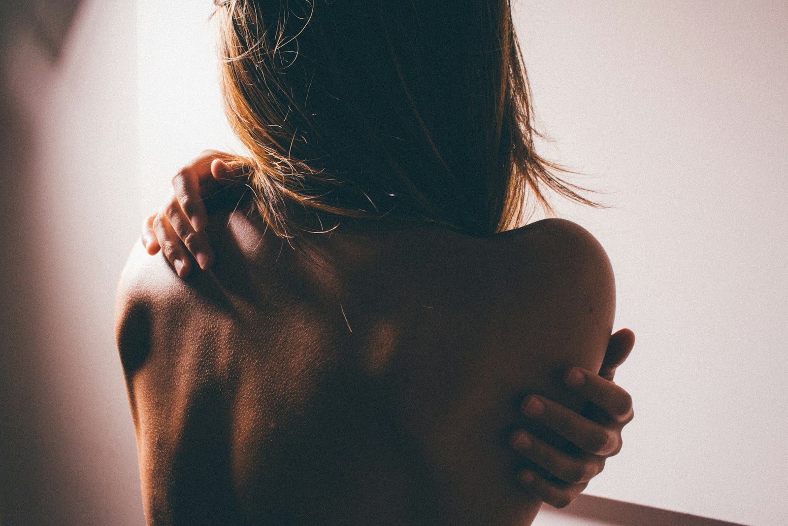 Dos d'une femme au hâle doré, lumière chaude de fin de journée