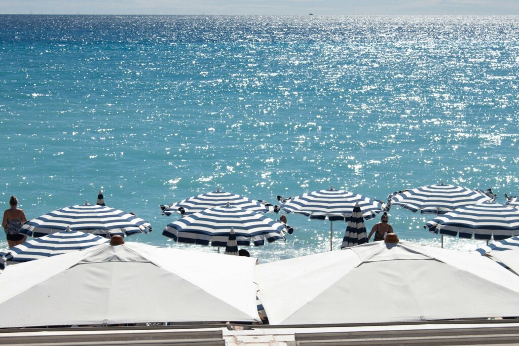 Parasols rayés alignés sur une plage ensoleillée au bord de la mer