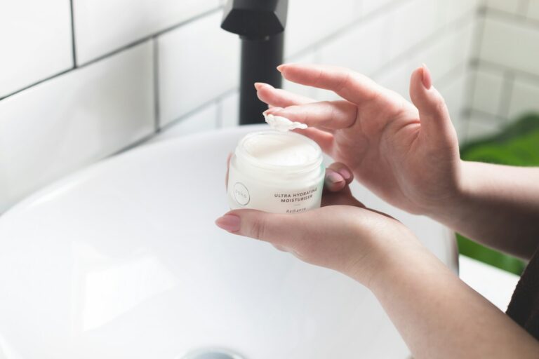 Femme appliquant un soin devant le lavabo de sa salle de bain