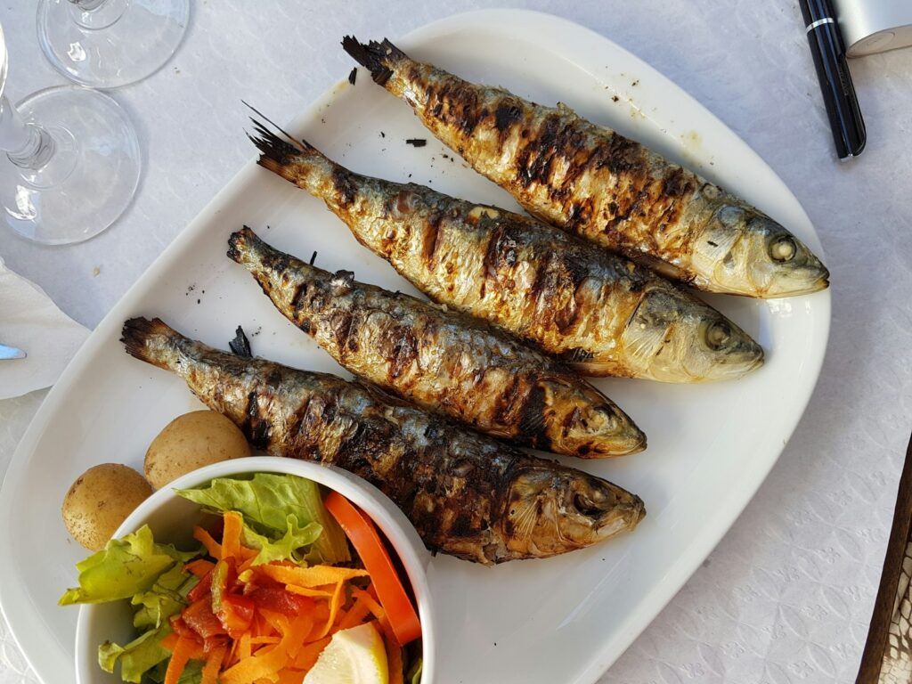 Assiette de sardines grillées servies avec une salade de légumes